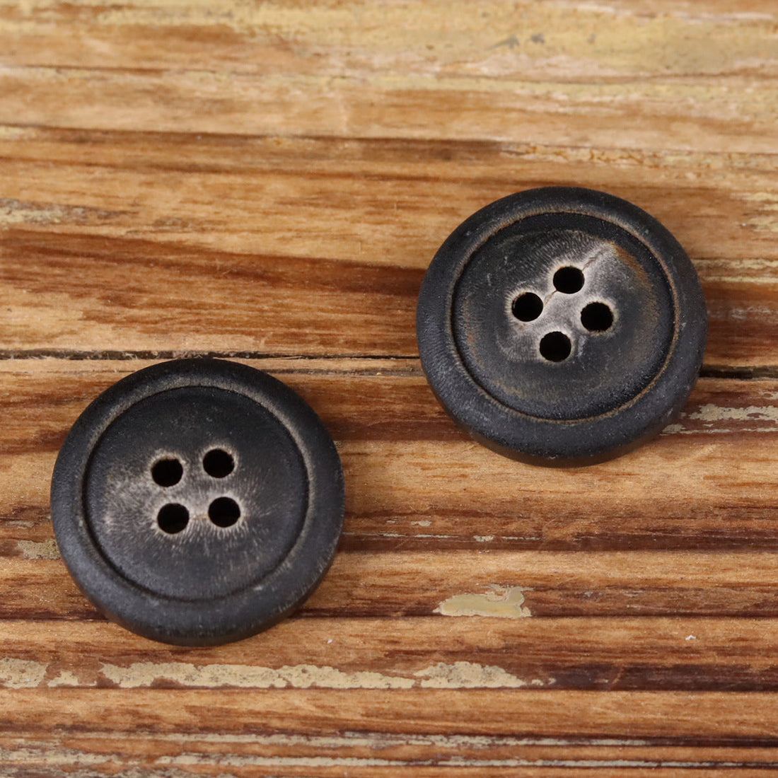 Natural horn button with four holes, dark black finish