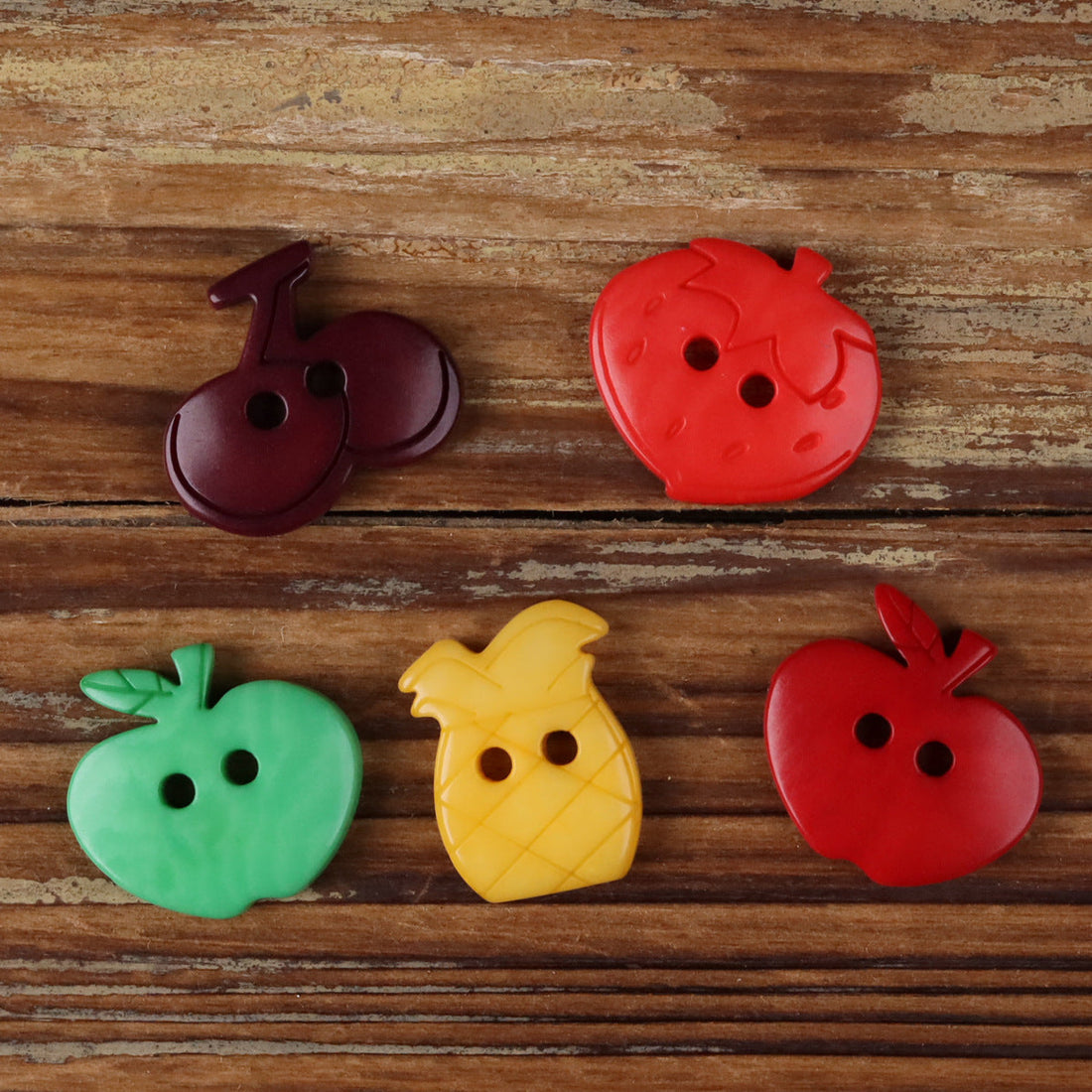 Fruit-shaped corozo buttons, red, green, yellow, and dark purple, assorted designs