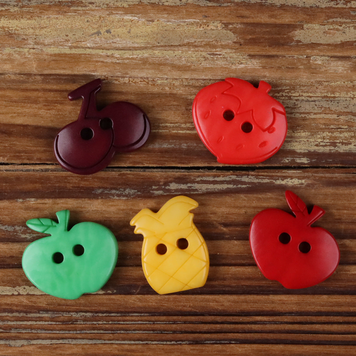 Fruit-shaped corozo buttons, red, green, yellow, and dark purple, assorted designs