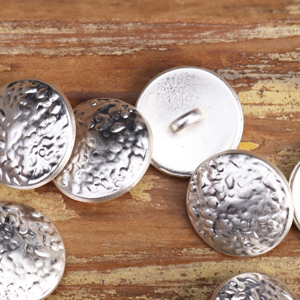 Round metal shank buttons with embossed vintage wave face in silver-toned metal.