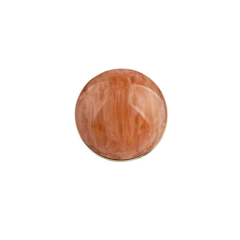Orange-brown round resin button with metal backing and shank