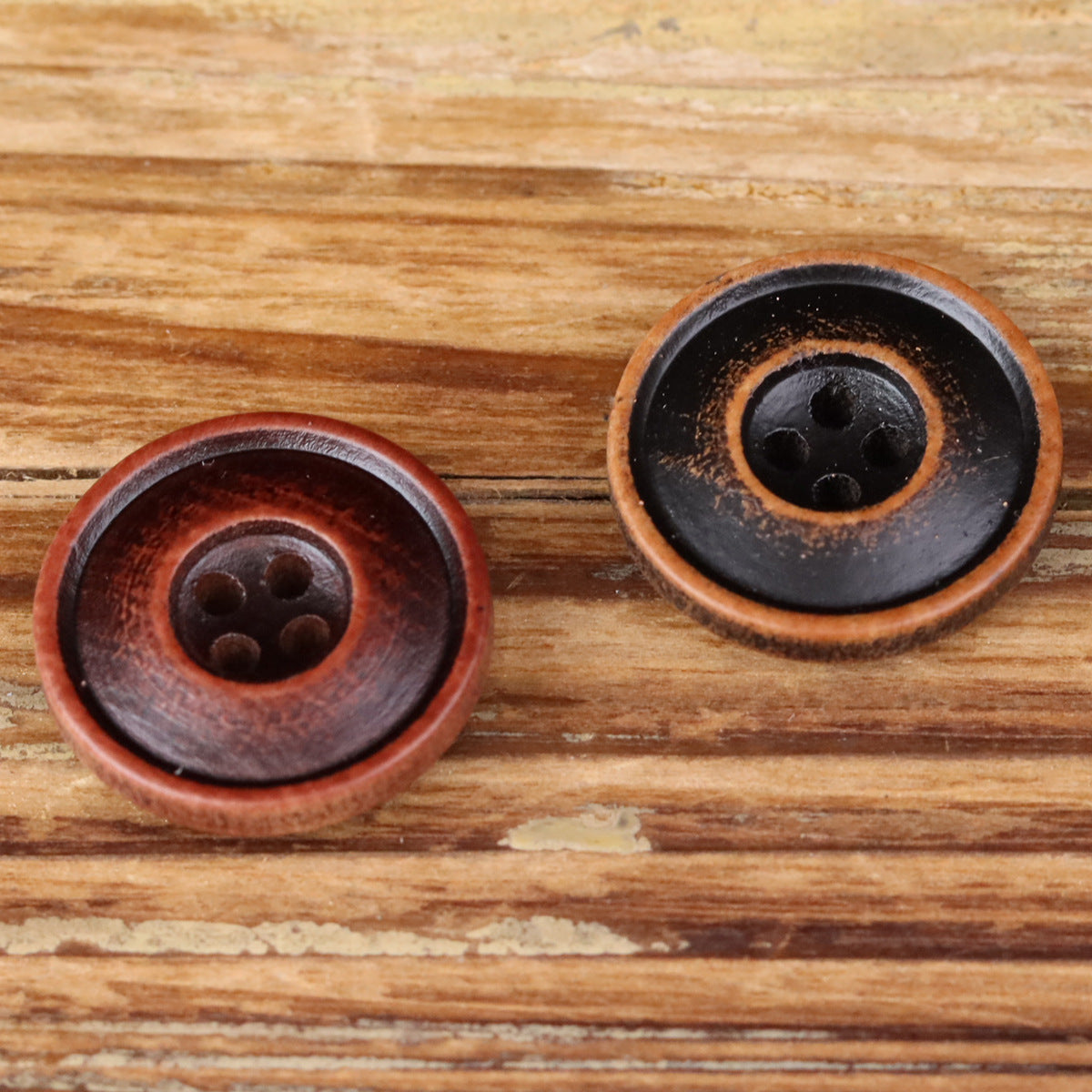 Round 4-hole double-ring buttons on wood grain, red and black pair