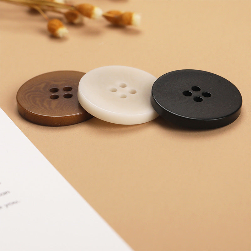 Assorted flat 4-hole buttons: brown, white-beige, and black