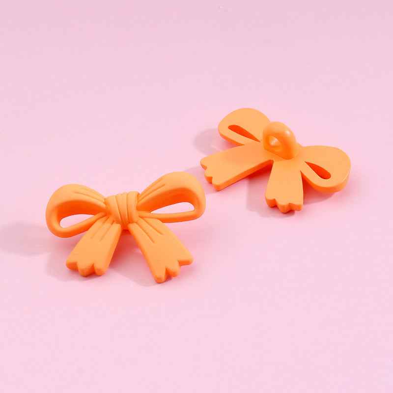 Orange bow-shaped plastic shank buttons with loop shanks, 2-piece view