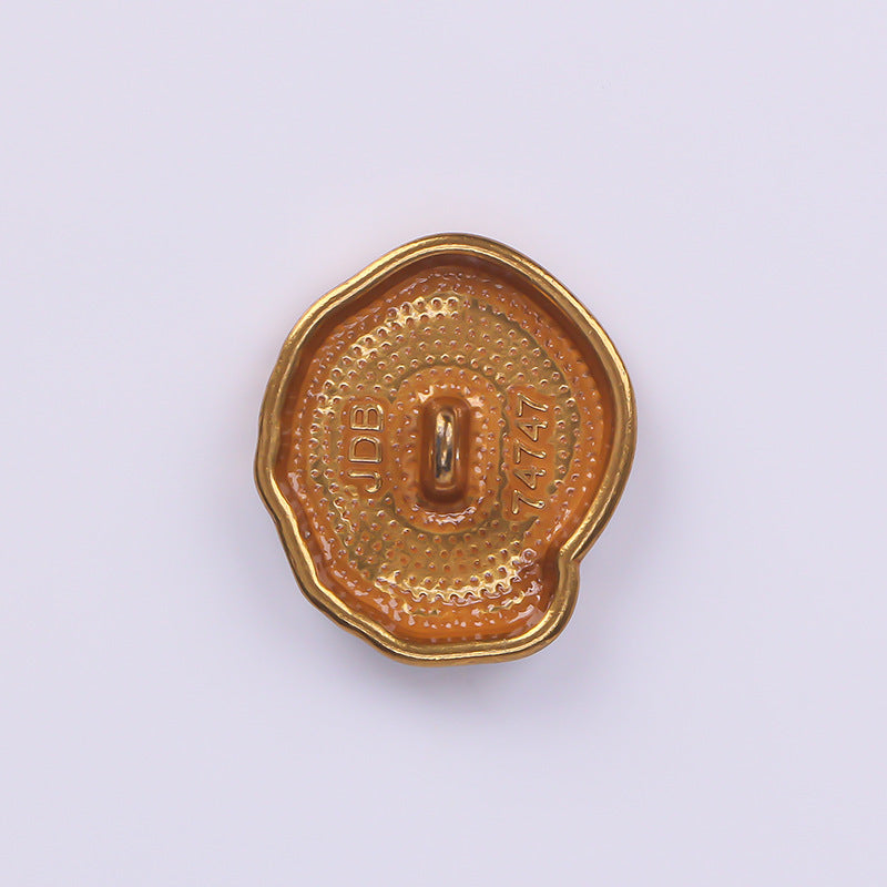 Antique gold metal button back with central shank and decorative embossed text