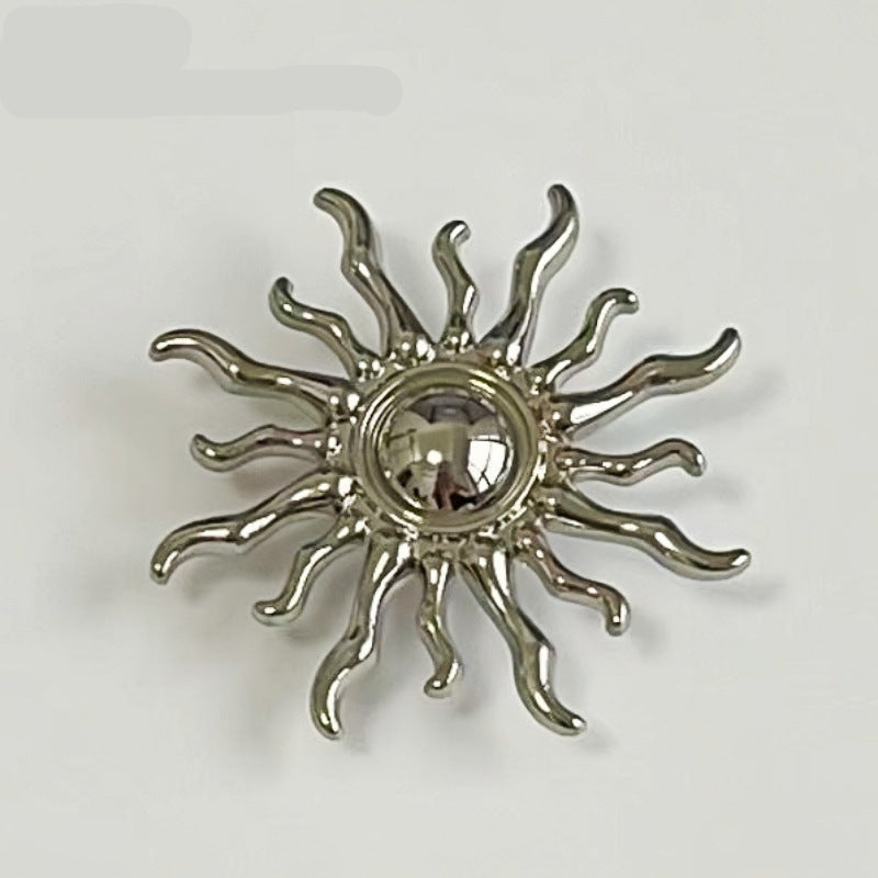 Sun-shaped metal shank button close-up, silver-tone rays with round center