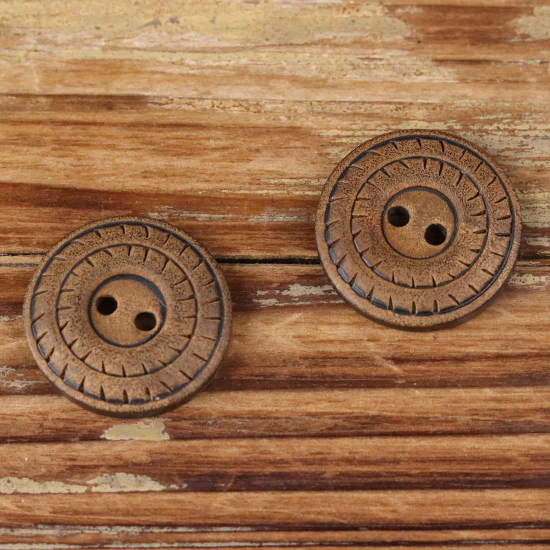 Round 2-hole natural horn button, close-up of carved rim details