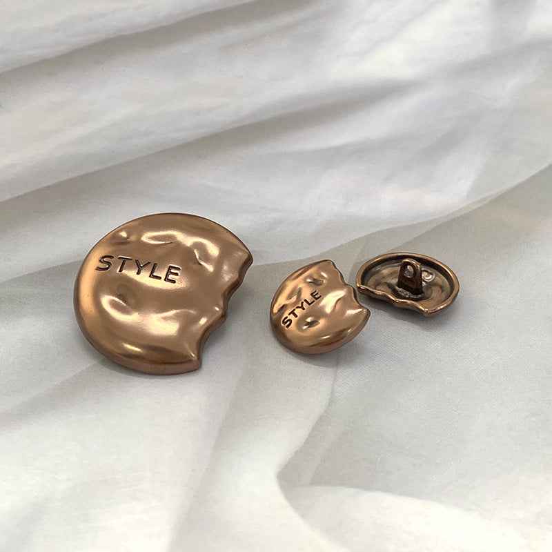 Gold semi-circular metal shank buttons, engraved “STYLE” on face and shank loop
