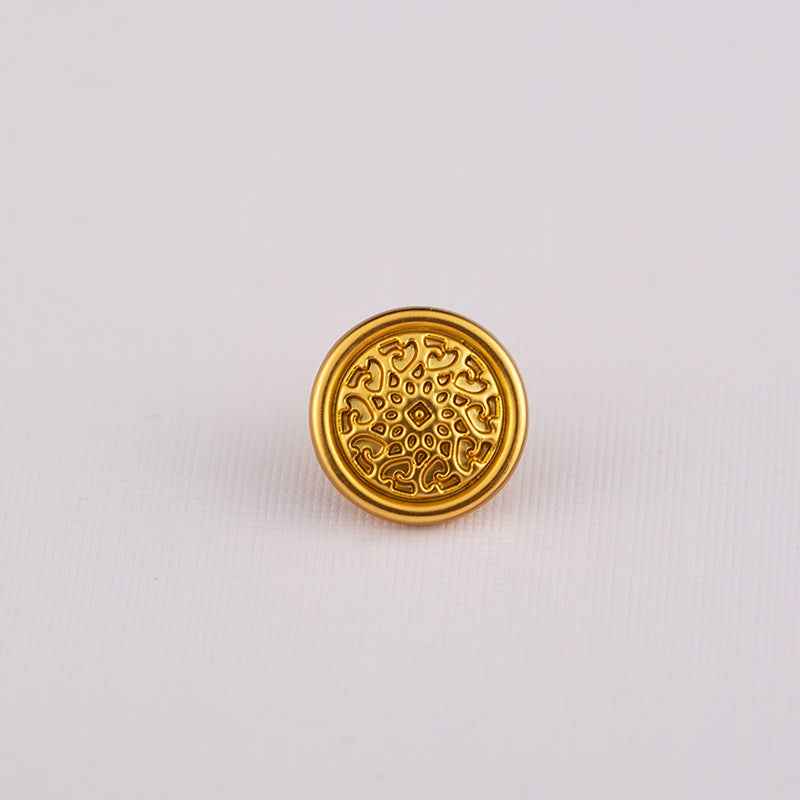 Gold Chinese-style shirt button with circular filigree and central dot pattern