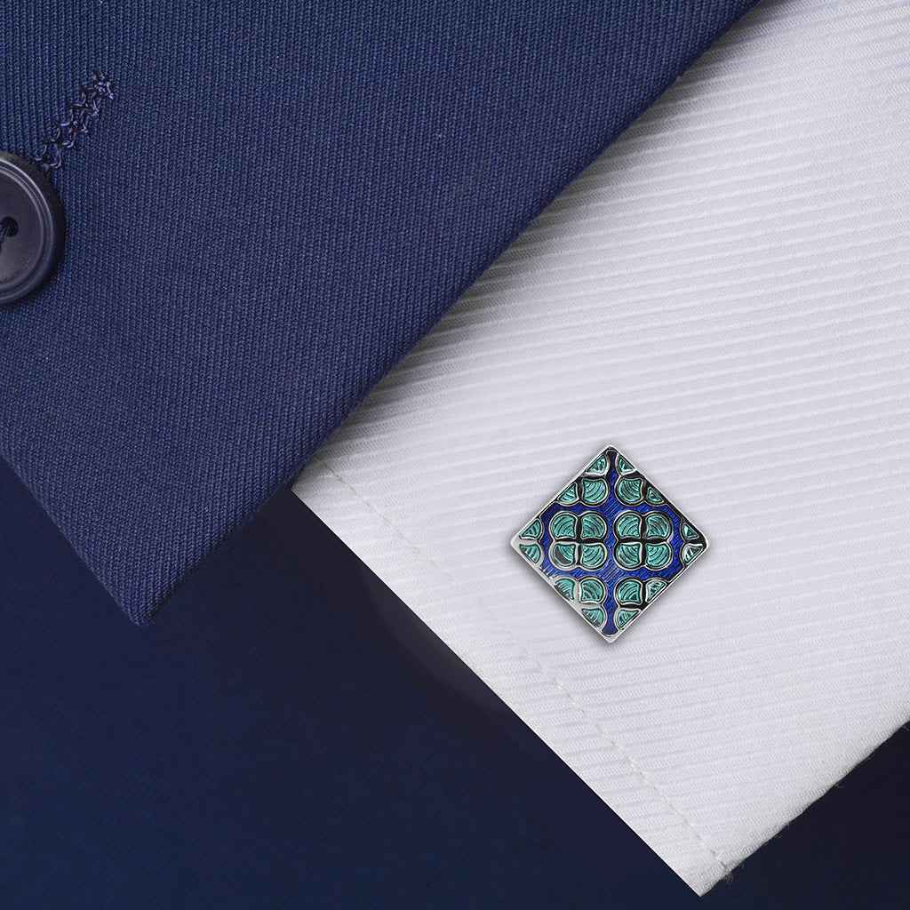 Square enamel cufflinks with blue background and green floral pattern, silver frame.