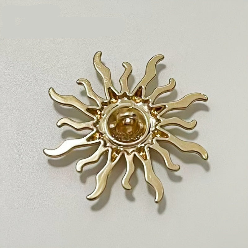 Close-up sun-shaped metal shank button, gold-tone with round center inset