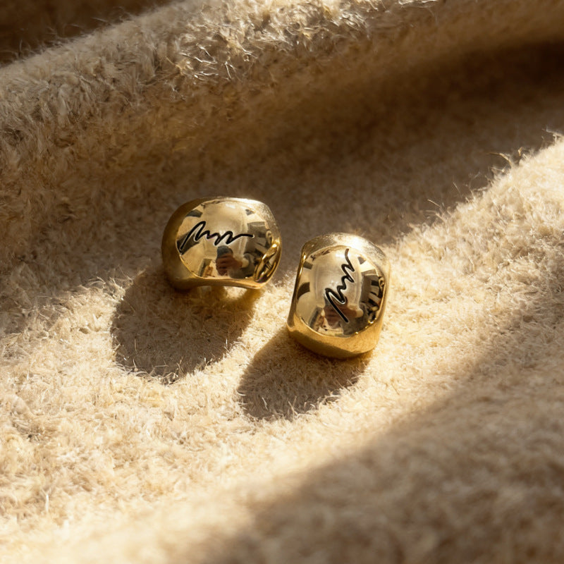 Pair of gold arched monogram metal buttons with engraved letter, glossy finish
