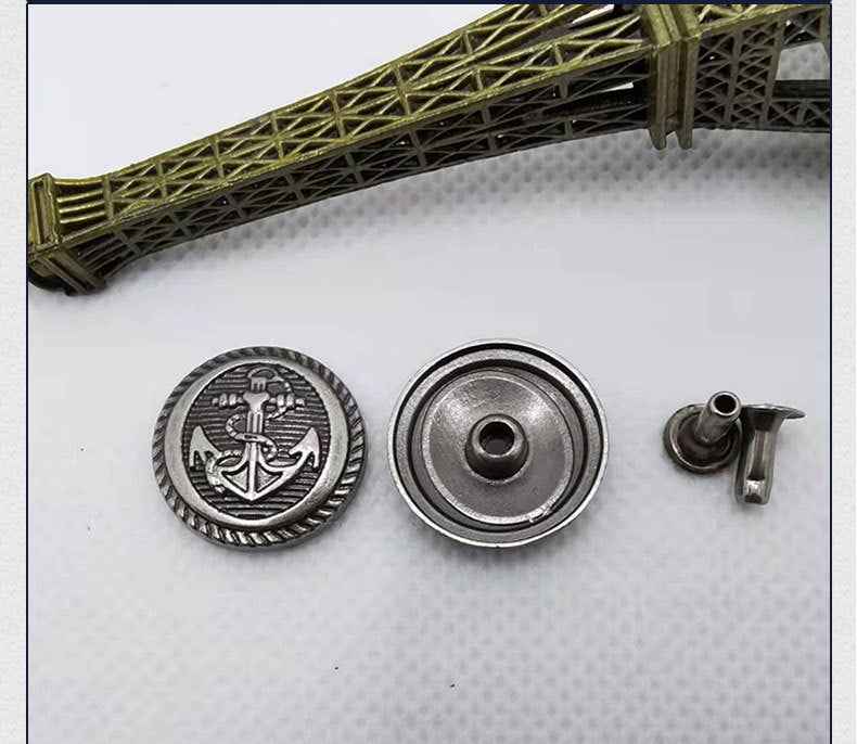 Round emblem anchor rivet with silver backing disc and small metal pin stud