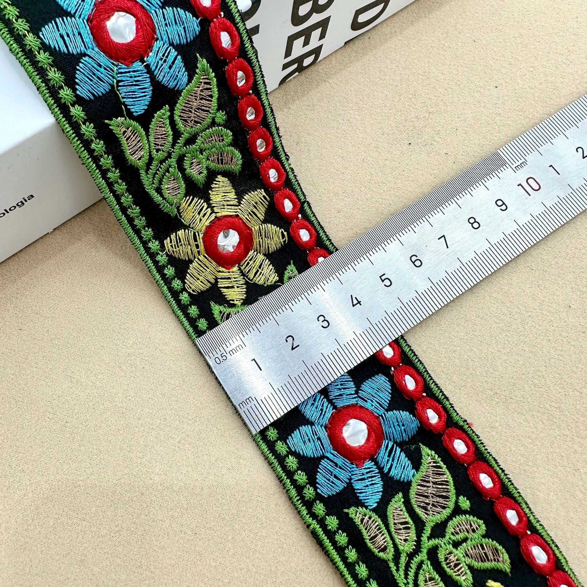 Sunflower lens lace trim on dark base, green border, blue flowers, red eyelets, yellow accents