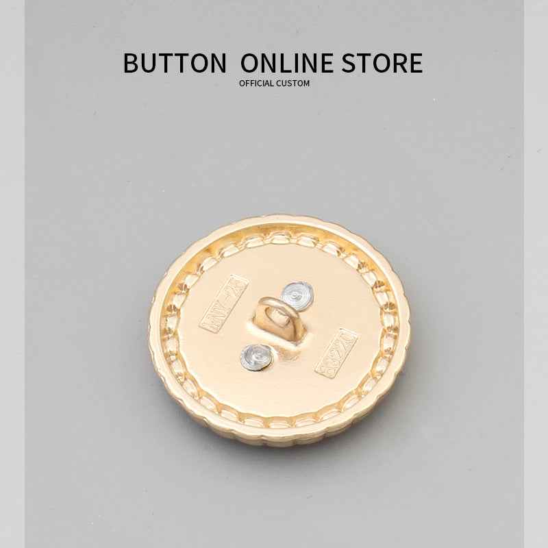 Round black-faced button, gold rim and chain, silver flower center, metal shank.