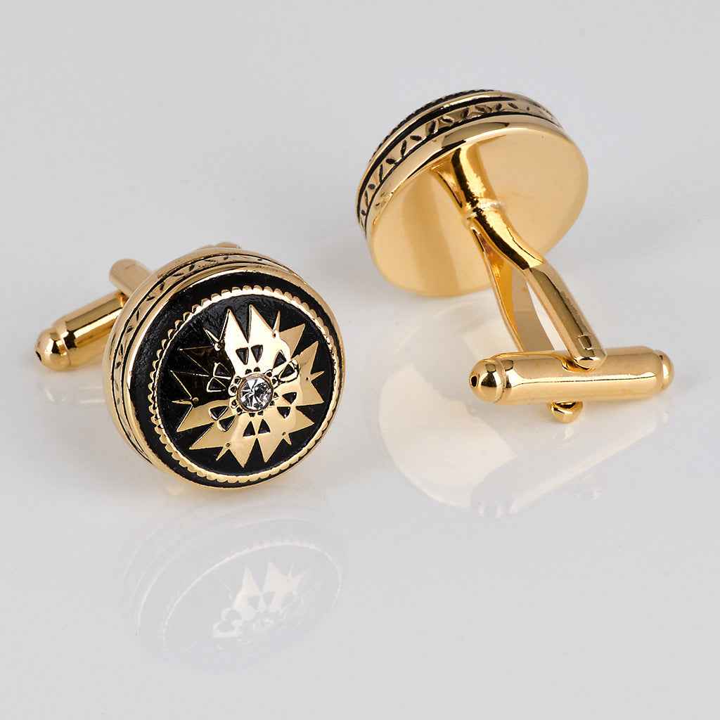Black-and-gold round French cufflinks with hinge bar and crystal starburst face