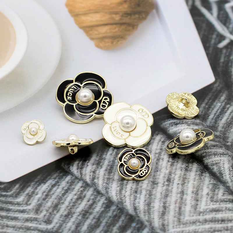 Black and white pearl petal metal shank buttons with gold backings and round center pearls