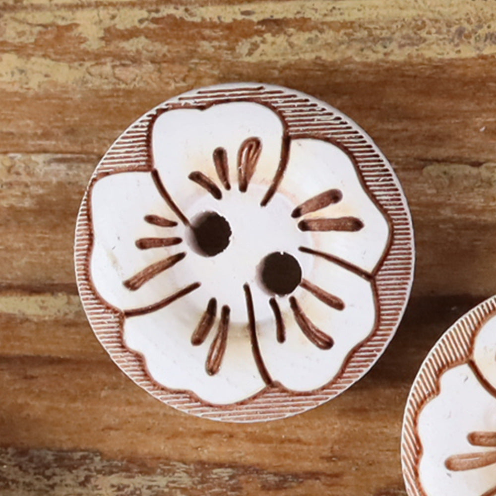 Round 2-hole wood button with painted floral pattern in light green and brown accents.