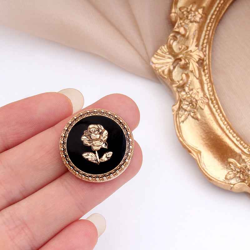Round metal rose shank button, gold rim and white face with embossed rose