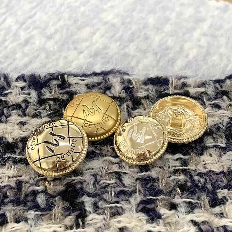Gold round metal buttons on fabric, engraved M-letter design, beaded edge