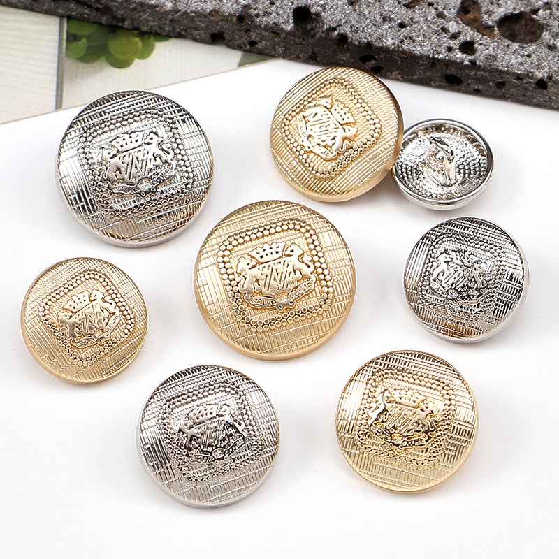 Mixed gold and silver speckled metal shank buttons, embossed crest-style center details