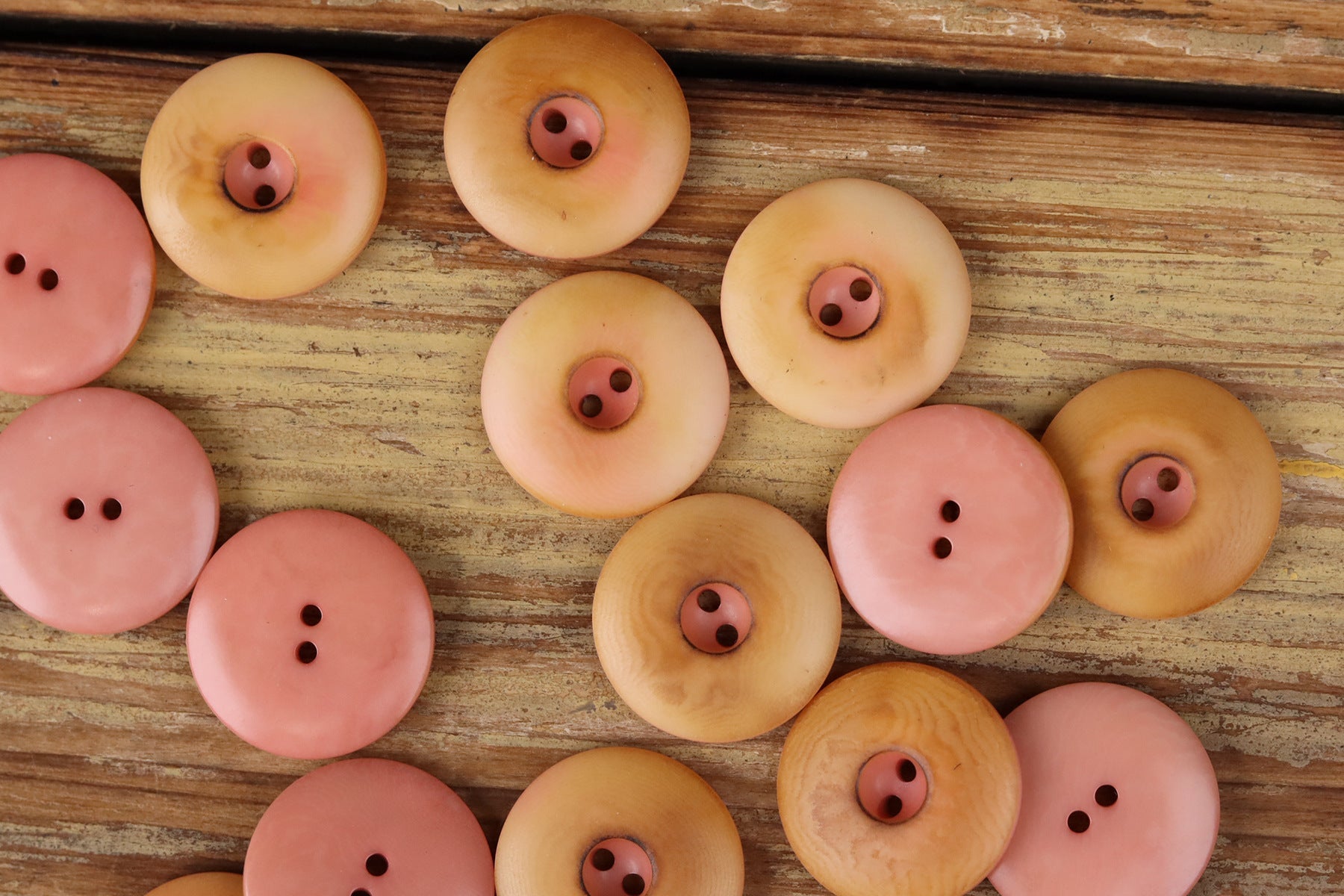 Round two-hole seed buttons in pink and pale yellow tones, assorted