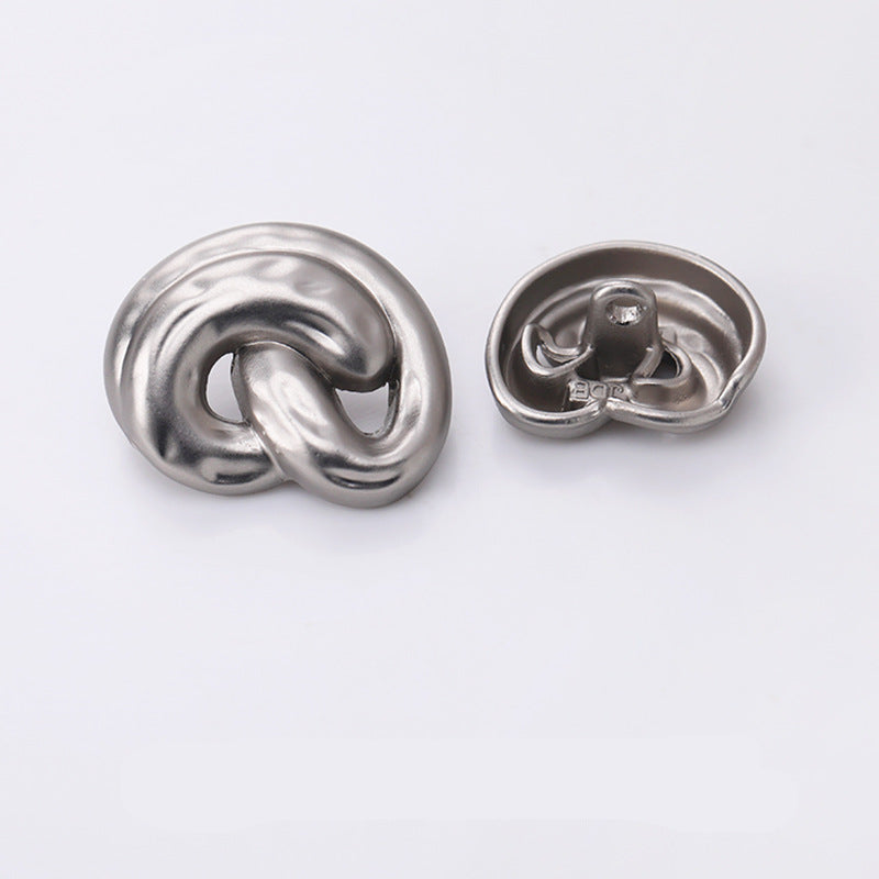 Silver ear-shaped metal shank button, back side with mounting prongs