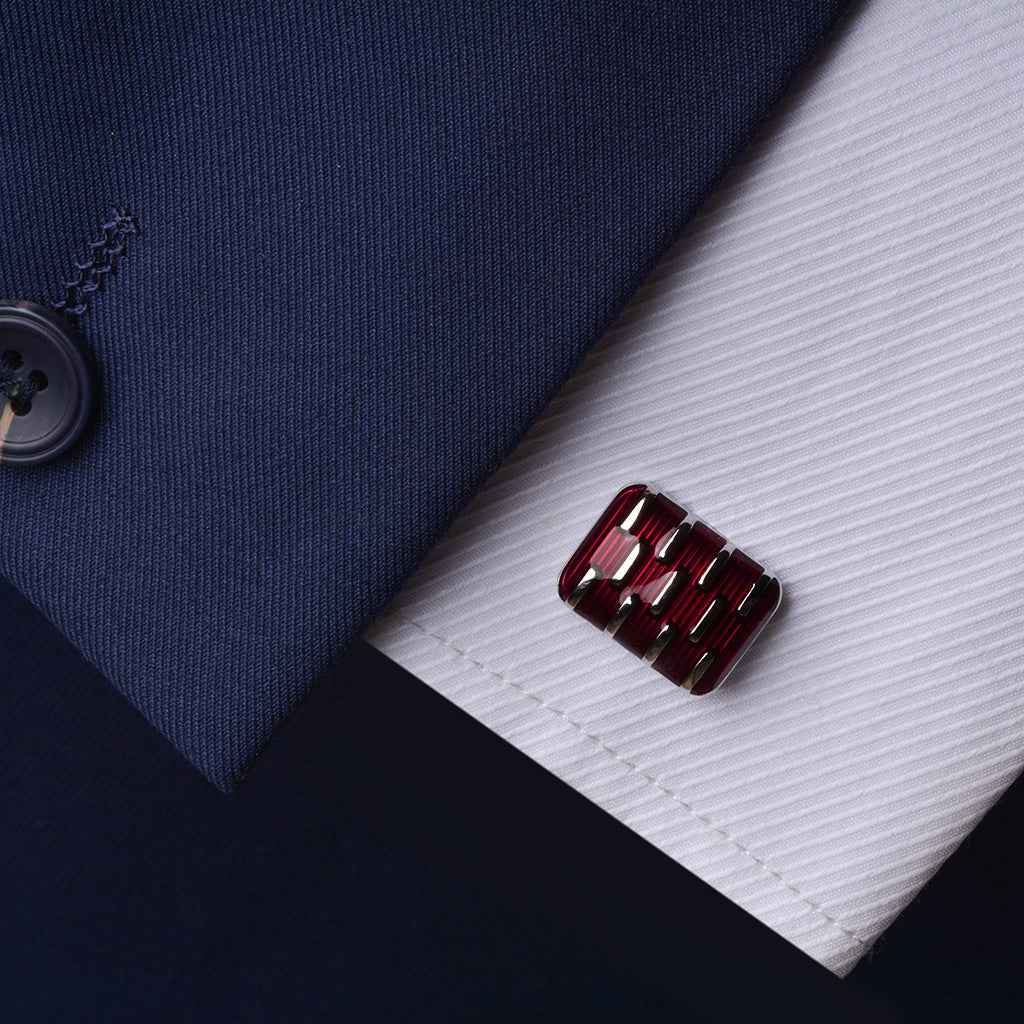 Red rectangular resin cufflink on white shirt cuff, silver backing visible
