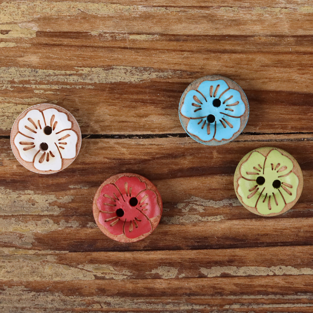 Round 2-hole wood buttons with painted floral designs in blue, white, green, and red.