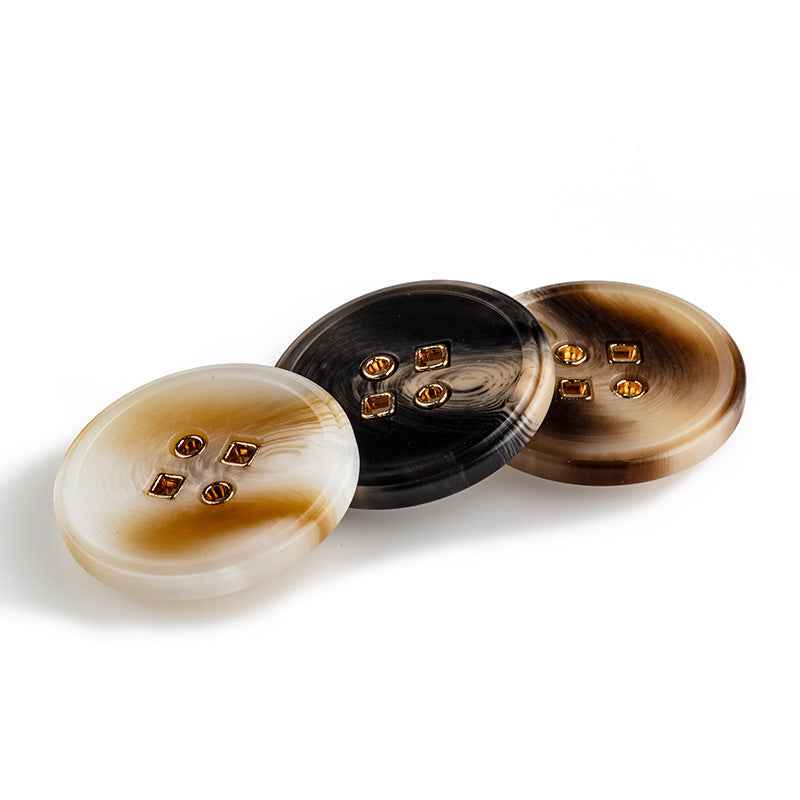 Three round resin buttons: beige, black, and coffee brown with four metal holes