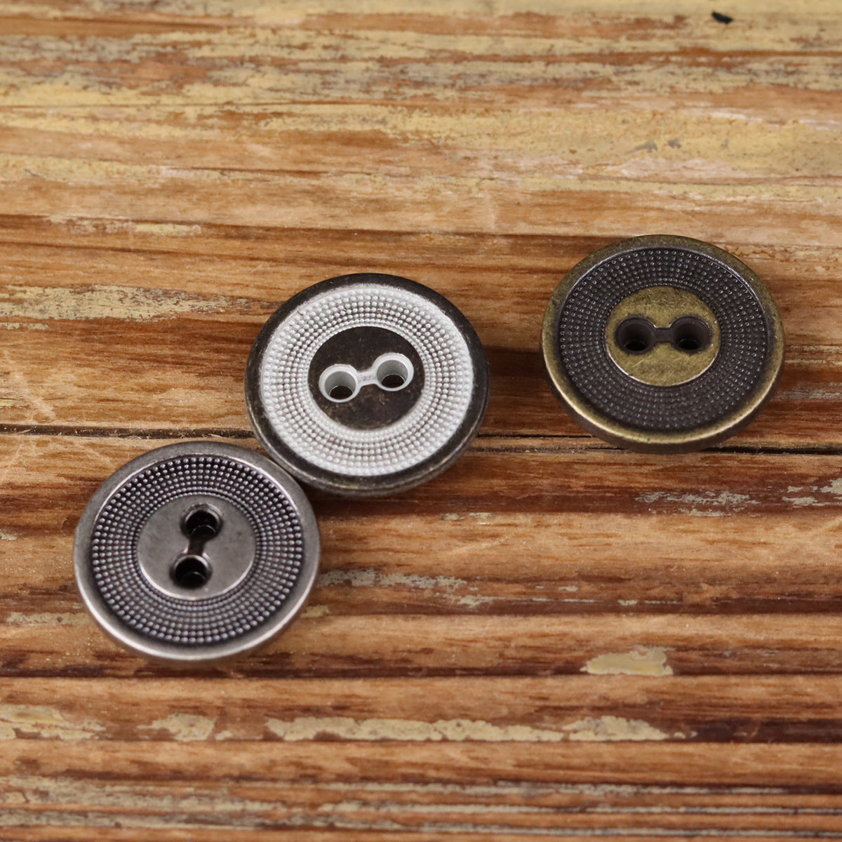 Set of three 2-hole metal buttons with concentric circle edging in dark and silver tones