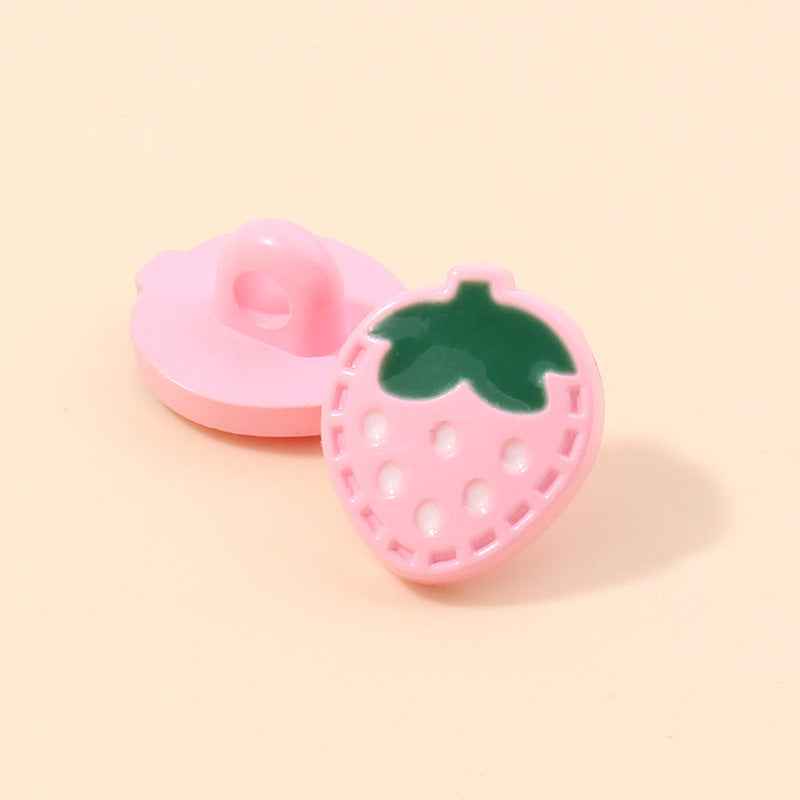 Pink strawberry-shaped plastic shank button with green leaf and white dotted holes