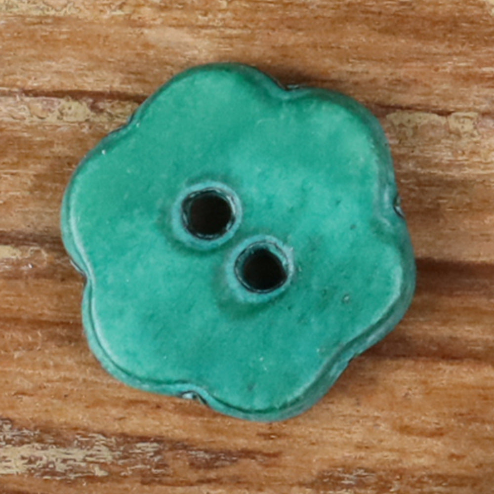 Turquoise novelty shirt button with two holes on a four-petal shape