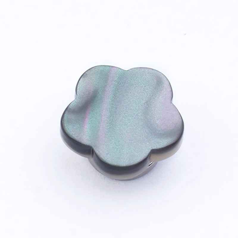 Clover-shaped magnetic collar clip in dark gray, domed face close-up