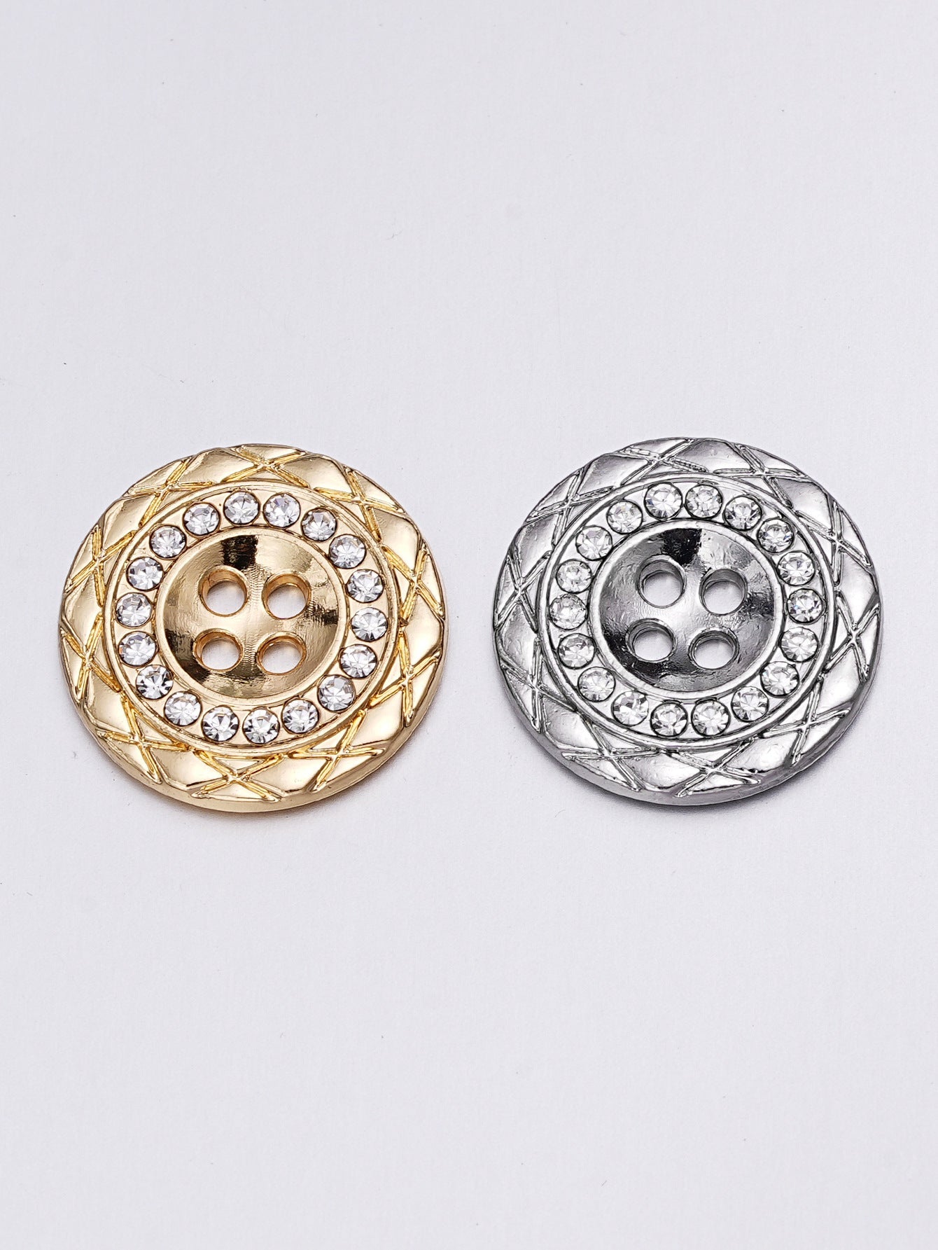 Pair of gold and silver round rhinestone buttons with 4 holes and ornate bezel