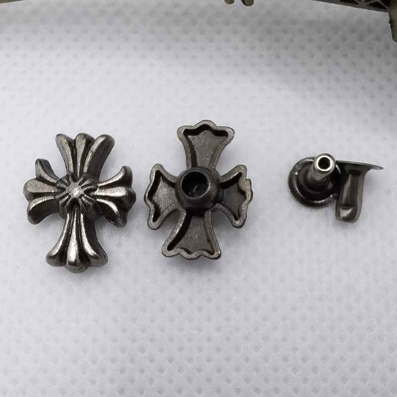 Dark silver cross and starburst rivet studs with one visible stud back.