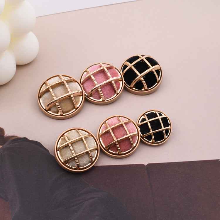 Set of fabric-covered sewing buttons: beige, pink, and black with gold stitching