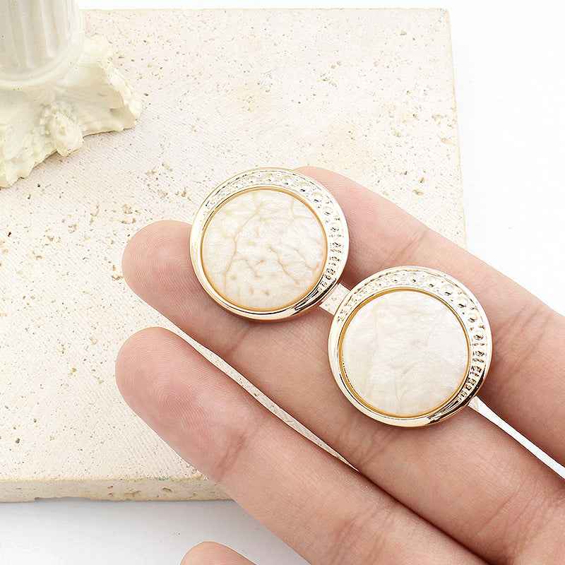 Round resin shank buttons, cream color, silver rim with detail, shown on stick shanks
