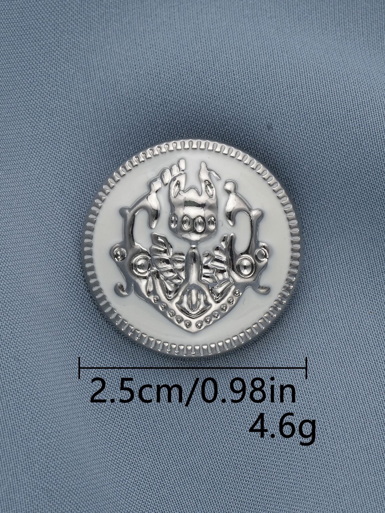 Gray-silver metal shank button, embossed crest medallion with raised border, 2.5cm.