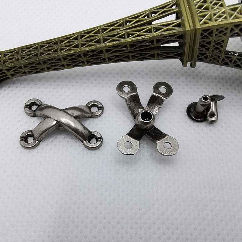 Back view of X rivet studs with metal legs and round holes for fastening.