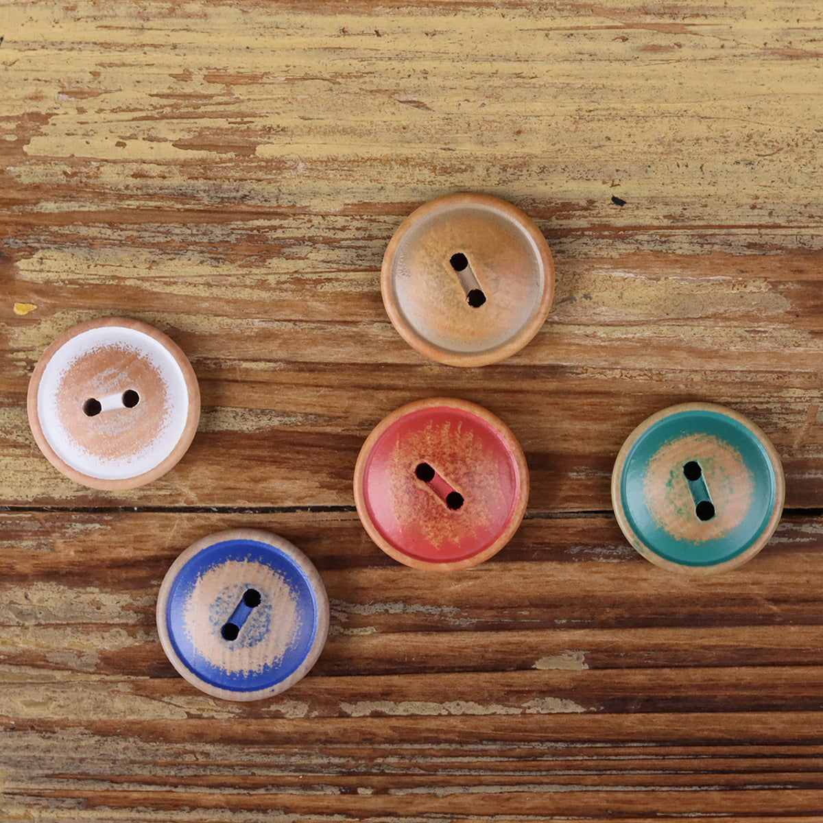 Round 2-hole wood buttons in blue, green, red, and light colors, shown laid out
