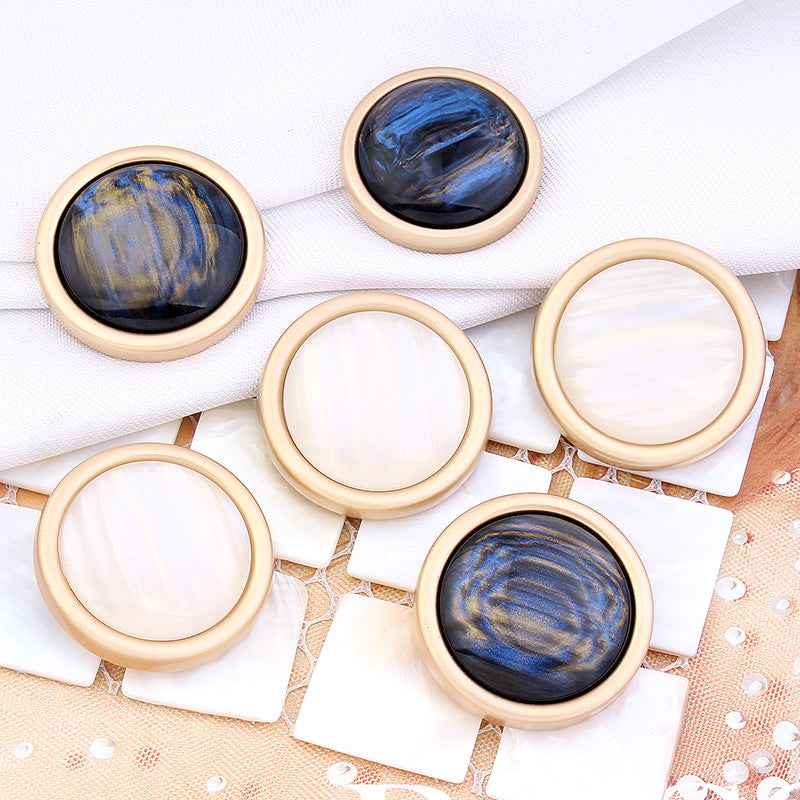Assorted cat’s eye shank buttons: white and blue-black faces with gold rims