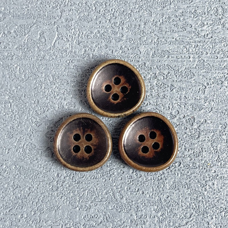 Four-hole wood buttons, three dark-inset faces with bronze rims arranged together.