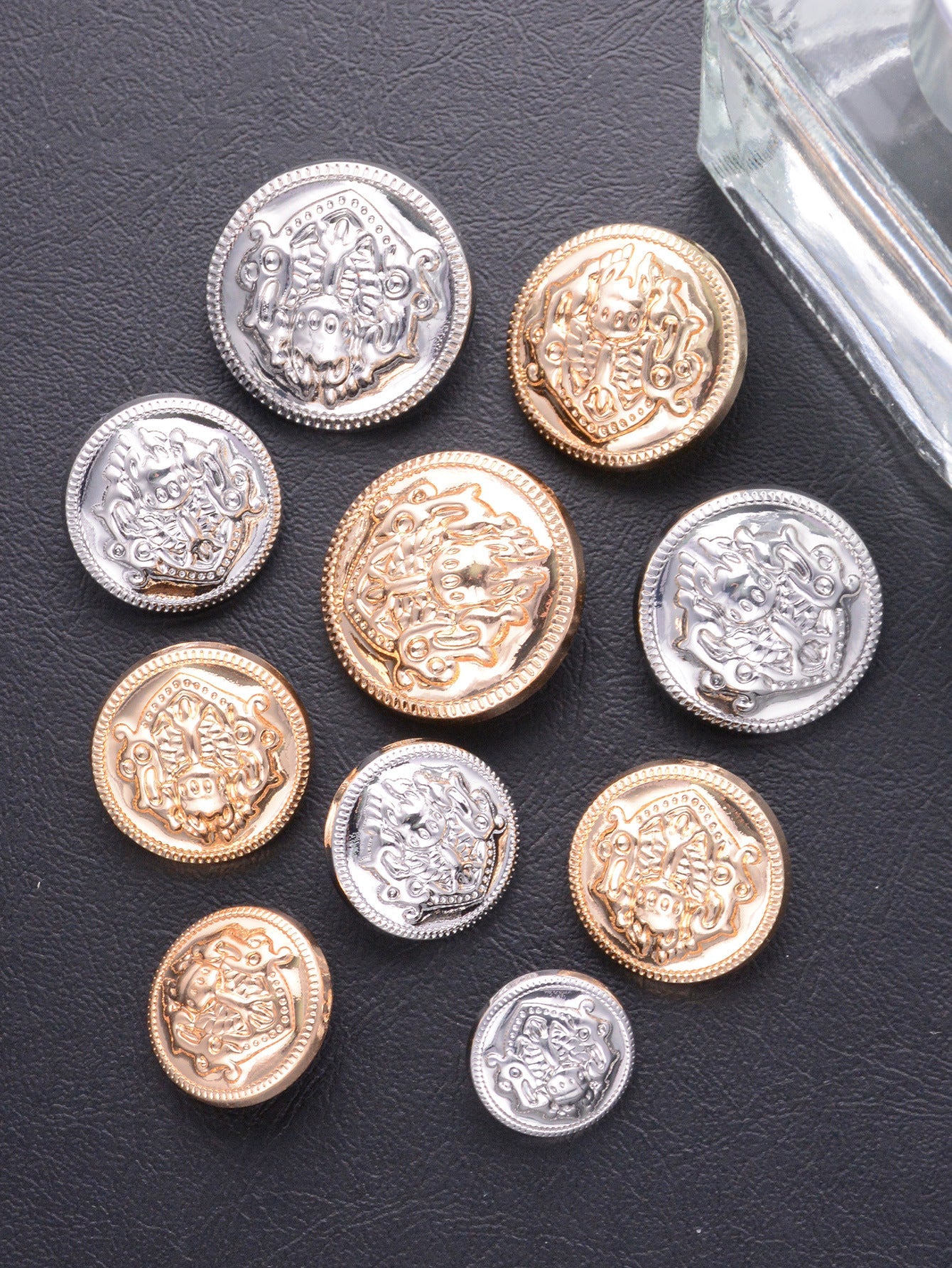 Mixed-color embossed crest medallion shank buttons: silver, gold, and rose-gold tones.