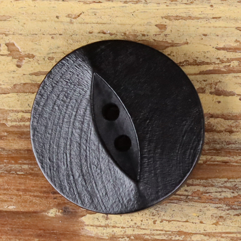 Round black wood 2-hole fish-eye button, textured surface, close-up