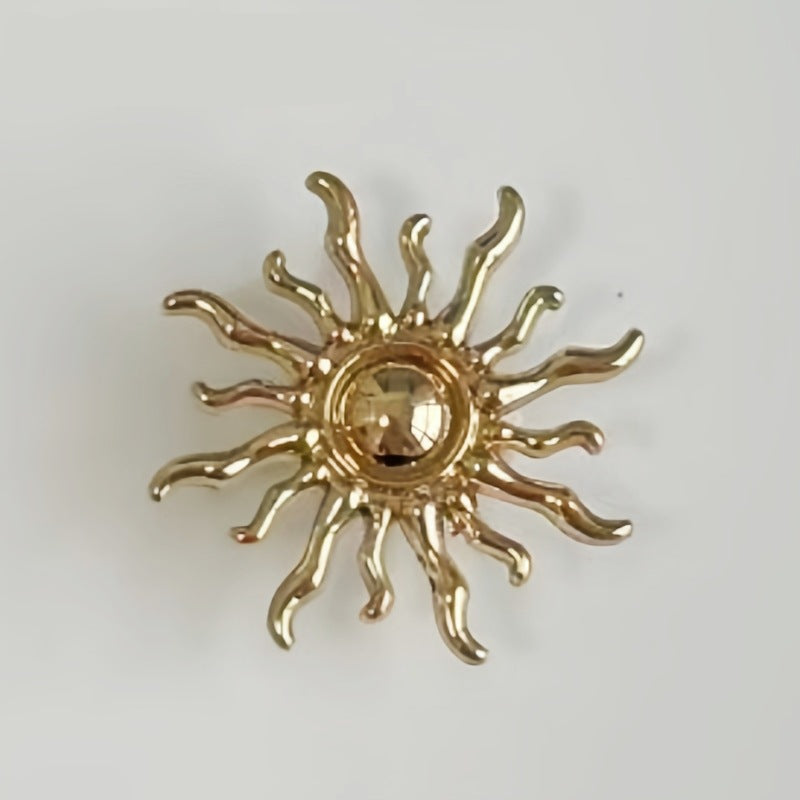 Sun-shaped metal shank button close-up, gold-tone finish with raised rays