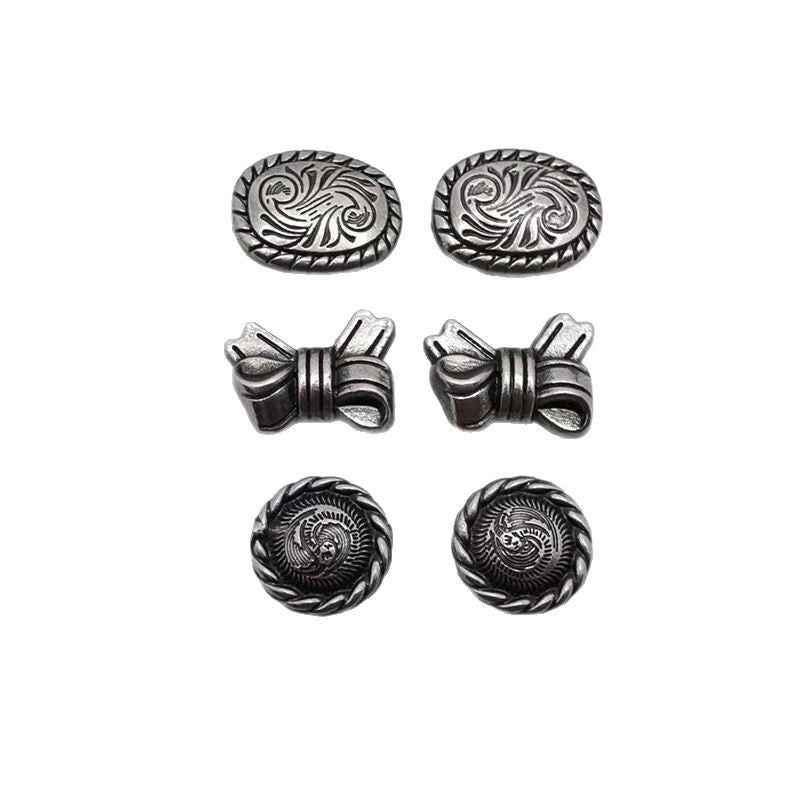 Ornate metal rivet studs: oval floral scroll, bow front, and round scroll caps.
