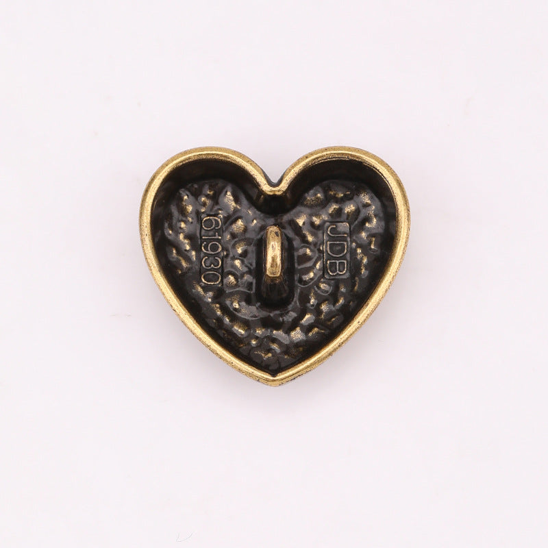 Heart-shaped metal shank button, engraved back with stem and decorative scale texture