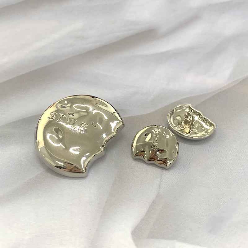 Gold semi-circular metal shank buttons, engraved “STYLE” on face and shank loop