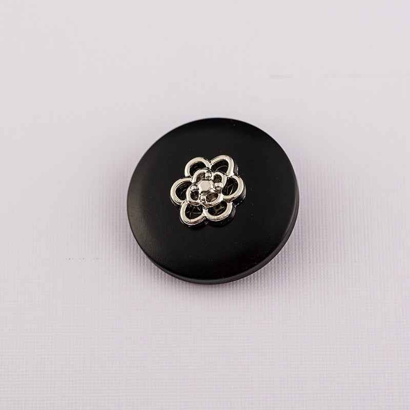 Matte black round resin button with metal shank and silver decorative center
